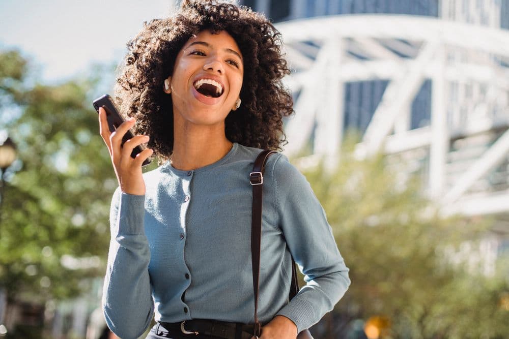 Happy seller holding smartphone after receiving completed payout